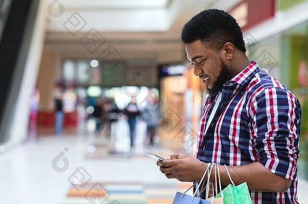应用程序折扣微笑黑色的男人。智能手机购物购物中心