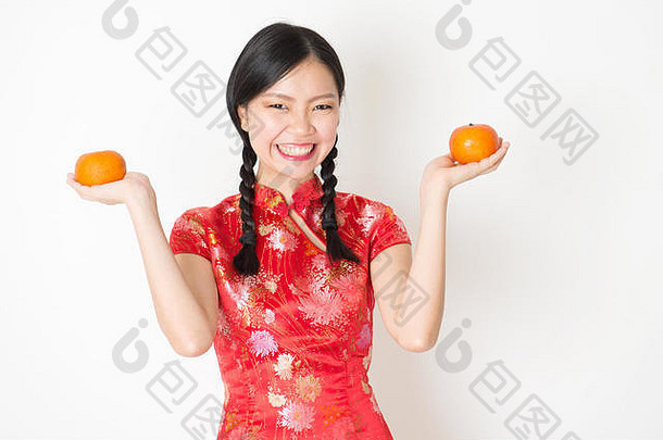 年轻的亚洲女人传统的旗袍衣服持有普通话橙色微笑庆祝中国人月球一年春天节日站