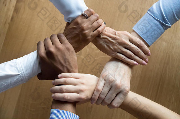 多样化的业务人团队把握手关闭前视图