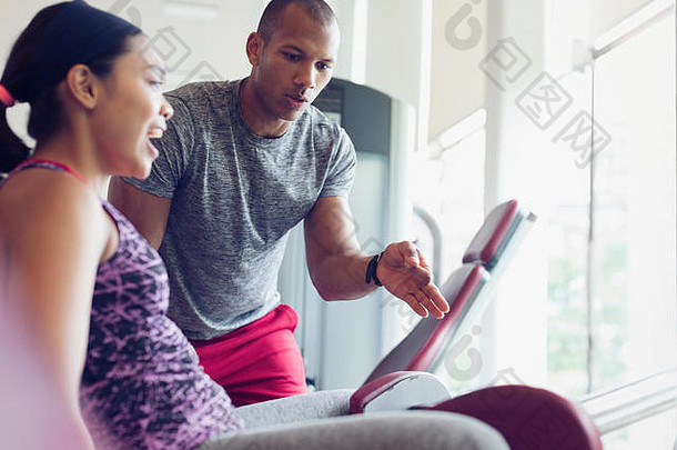 个人教练指导女人锻炼设备健身房