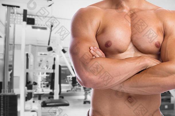 健美运动员健身弯曲胸部肌肉摆姿势健身健身房身体构建器建筑强大的肌肉发达的男人。工作室