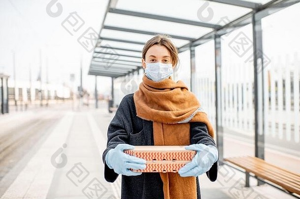 年轻的女人医疗面具手套持有纸板披萨的食物疫情概念外卖食物检疫