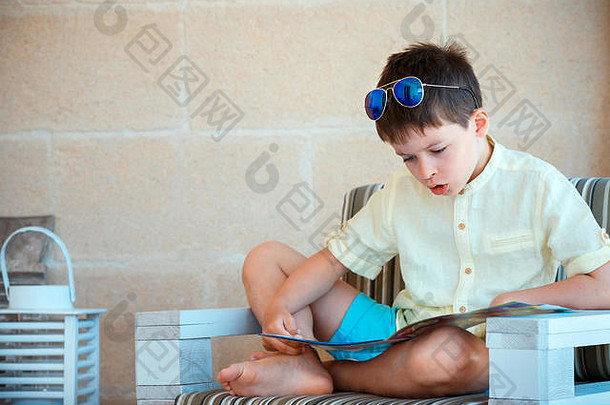 年轻的男孩阅读书户外阳台
