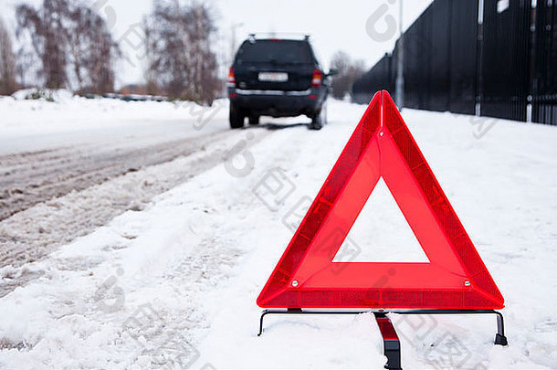 破碎的车停警告三角形雪街