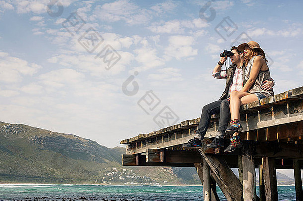 年轻的夫妇坐着边缘码头双筒望远镜角小镇西方角南非洲