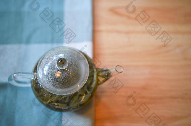 <strong>摄影图</strong>像热新鲜的能茶清晰的<strong>玻</strong>璃茶壶使绿色叶木表格布空间