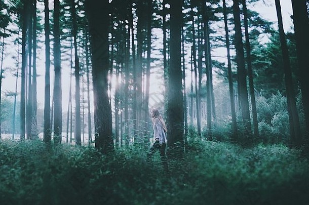 一边视图年轻的女人走森林