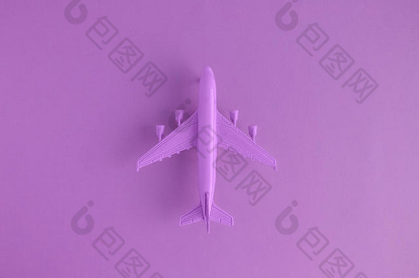 平躺微型玩具飞机紫罗兰色的背景最小的旅行旅行有创意的概念
