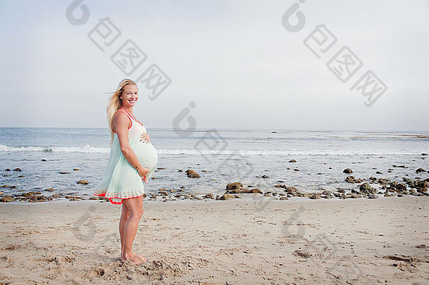 肖像怀孕了年轻的女人海滩