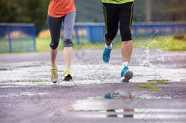 年轻的夫妇慢跑沥青多雨的天气