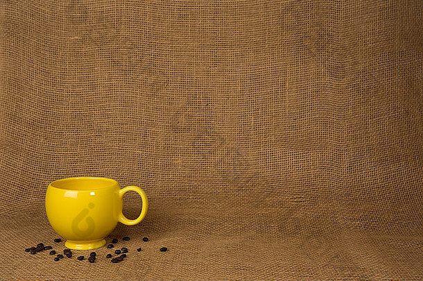 咖啡杯子背景黄色的杯子豆子粗麻布复制空间