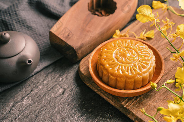 中秋节日传统的食物概念美丽的月亮蛋糕黑色的板岩表格茶糕点模具花关闭复制空间