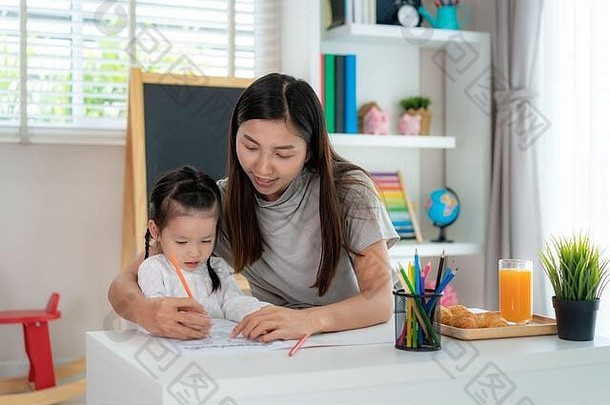 亚洲幼儿园学生女孩妈妈。绘画图片书颜色铅笔首页在家教育距离学习