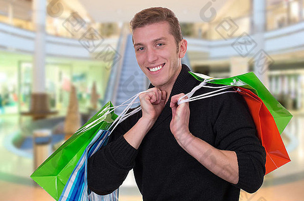 微笑年轻的男人。购物购买商店购物中心