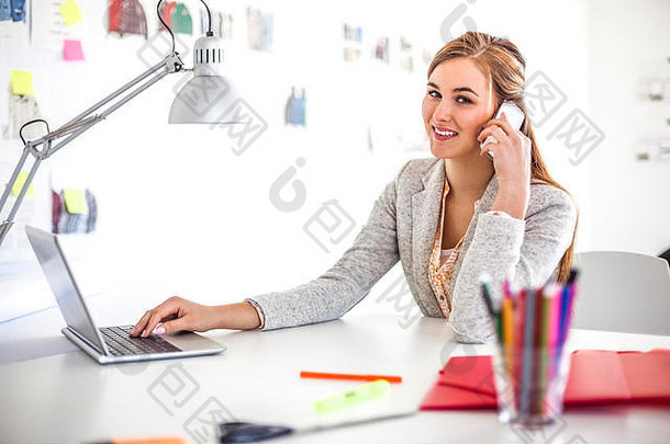 肖像年轻的女商人细胞电话移动PC办公室