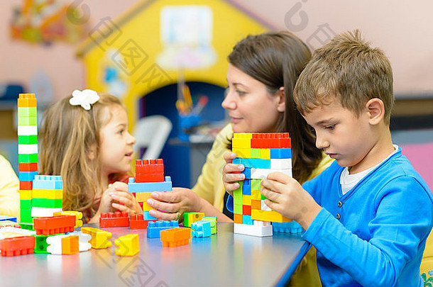 孩子们玩塑料建筑块幼儿园