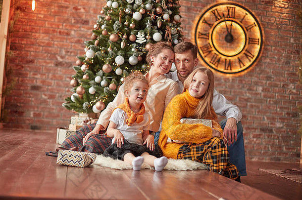 快乐家庭坐着圣诞节树舒适的生活房间