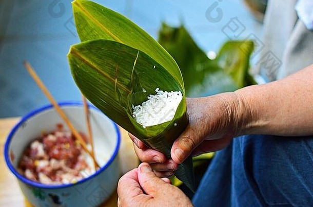 使粽子传统的中国人大米饺子龙船节日手持有叶填满黏糊糊的大米猪肉馅料模糊回来