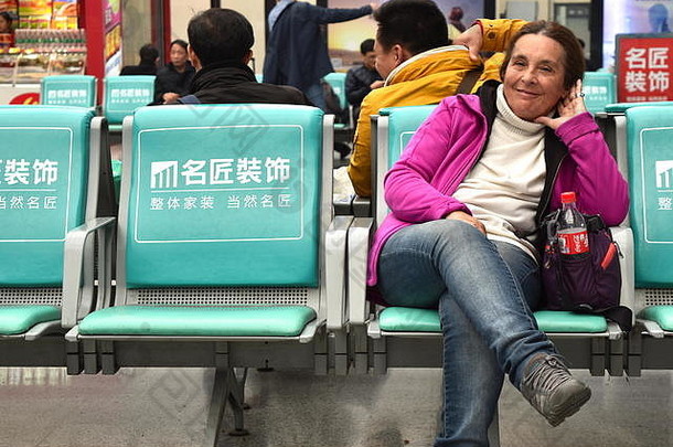活跃的高级女人旅行者坐着中国人快速铁路站等待区域长沙中国