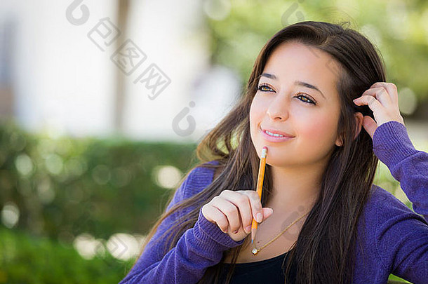 有吸引力的沉思的混合比赛女学生铅笔坐着校园板凳上