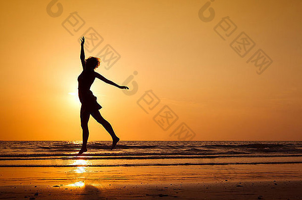 轮廓快乐女人跳海滩健康的生活方式