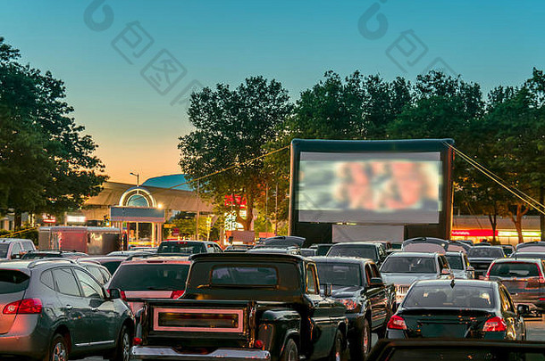 看电影在户外车城市停车很多温暖的夏天晚上