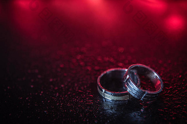 两枚红色背景的金色结婚戒指