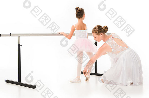 后视图女老师图图检查尖端鞋子芭蕾舞女演员锻炼芭蕾舞巴利站孤立的白色背景