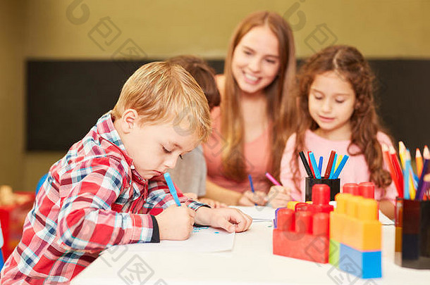 男孩油漆彩色的铅笔绘画类一天护理中心学前教育
