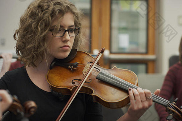 十几岁的女孩音乐家玩小提琴乐队类