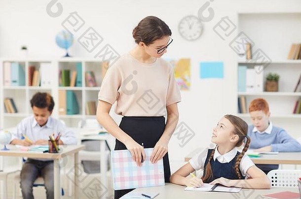 年轻的老师站会说话的女学生教训孩子们背景
