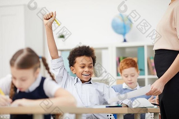 非洲小学生坐着桌子上快乐好马克老师显示纸教室
