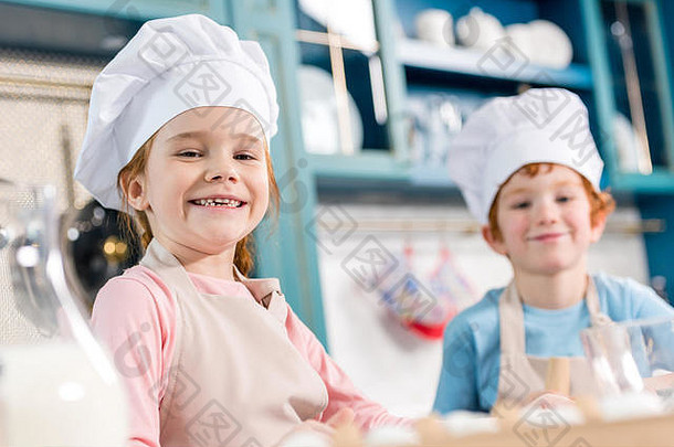 可爱的孩子们老板帽子围裙微笑相机烹饪厨房