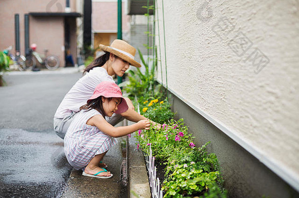 家庭首页女人女儿照顾植物狭窄的带土壤