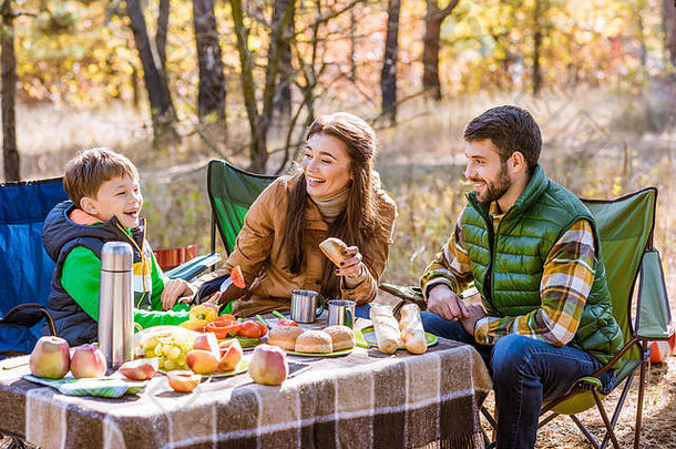 快乐微笑家庭吃有趣的坐着表格野餐秋天森林
