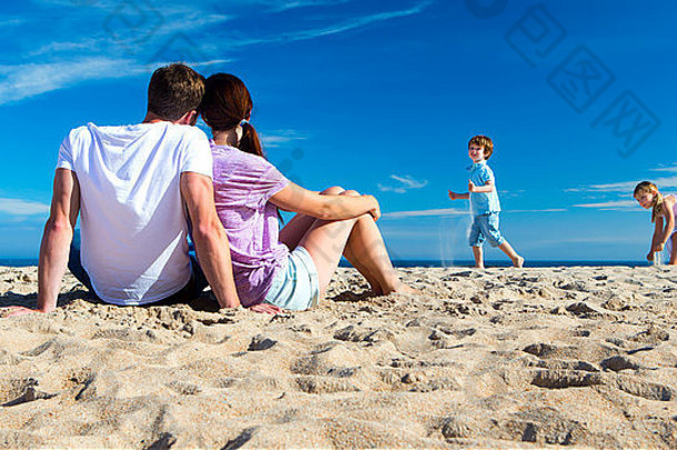 妈妈。父亲看孩子们玩海滩