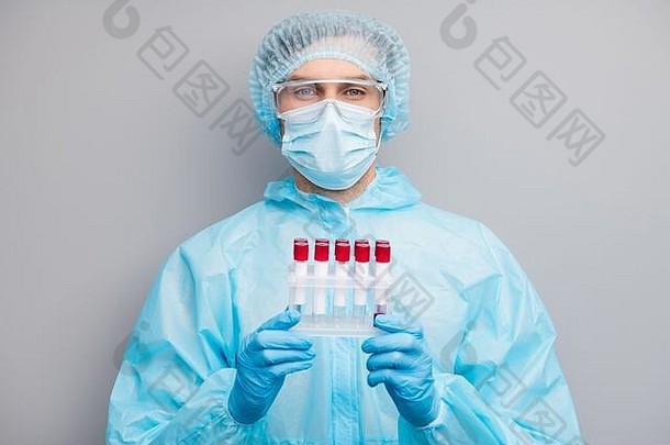 照片的家伙专家医生病毒学家持有生病的科维德病人血探针管检查结果穿面具有害物质蓝色的统一的外科手术帽西装