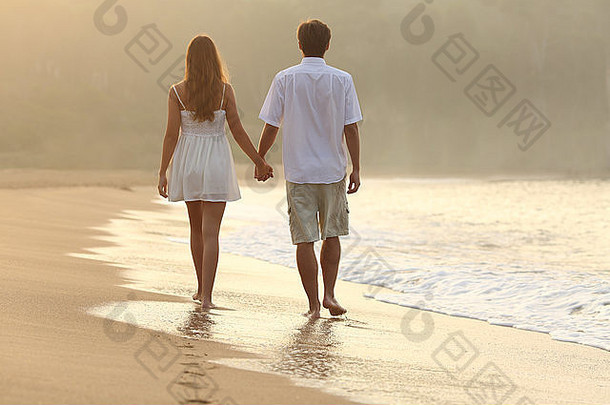 回来视图夫妇走持有手沙子海滩日落