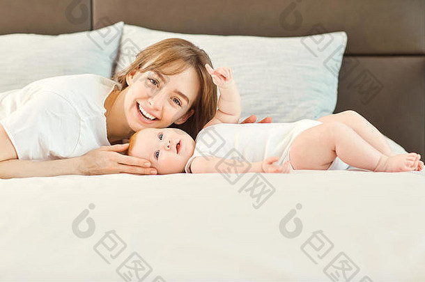 妈妈和孩子微笑地躺在床上