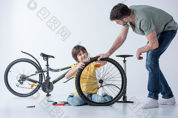 儿子父亲修复自行车轮胎工作室白色