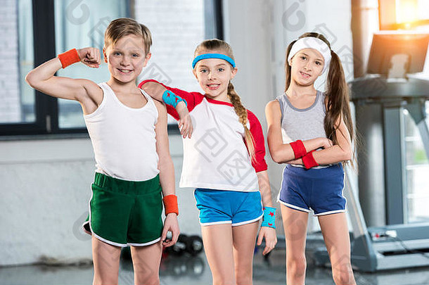 可爱的孩子们运动服装微笑摆姿势健身工作室孩子们体育运动概念