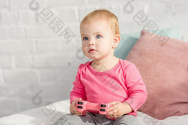 可爱的孩子粉红色的衬衫持有粉红色的操纵杆床上孩子们房间