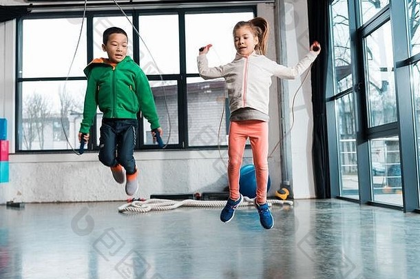 前面视图多元文化的孩子们锻炼跳绳子健身房