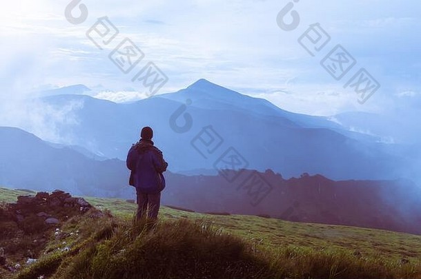 男人。轮廓多云的山旅行概念景观摄影