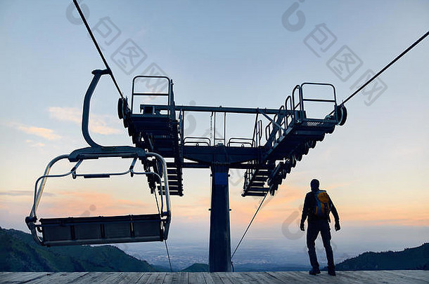 旅游男人。走滑雪电梯站轮廓高山滑雪度假胜地日出