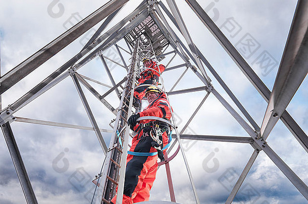 塔工人攀爬广播塔离岸风电场低角视图