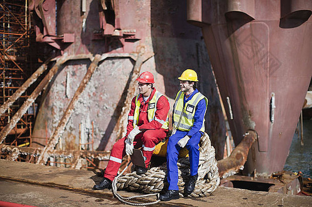 工人坐着绳子石油钻井平台