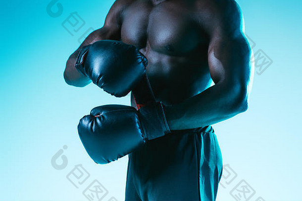 裁剪视图赤膊上阵肌肉发达的非洲美国运动员拳击手套蓝色的背景