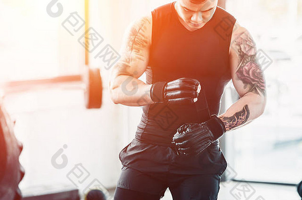 裁剪视图年轻的运动员穿拳击手套健身房阳光