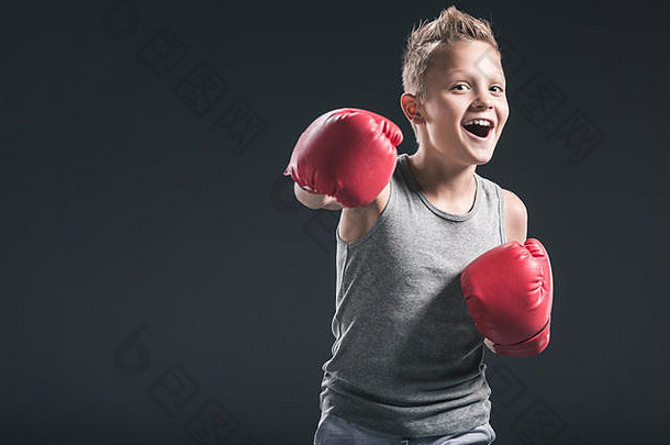 肖像快乐的男孩红色的拳击手套黑色的背景